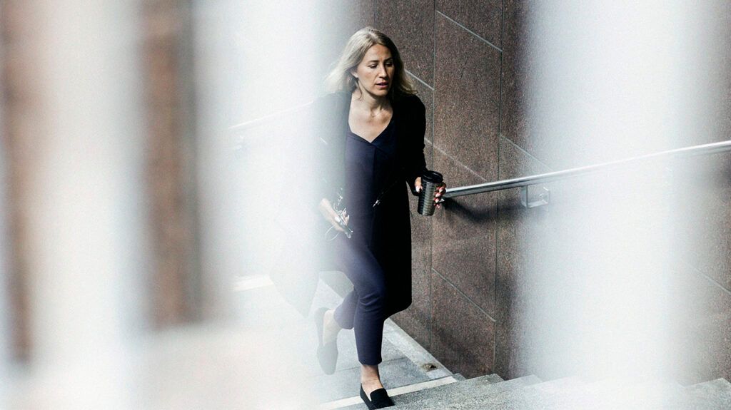 A person walking up steps beside a handrail.