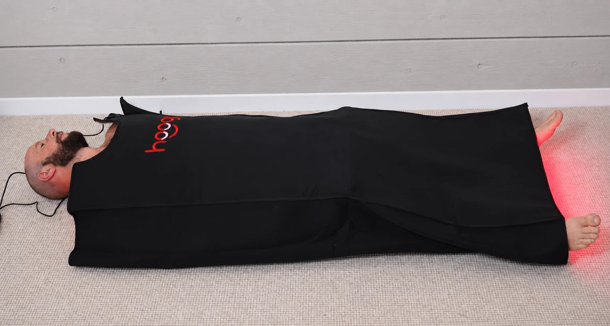 An adult lying in a flexible LED body pod.