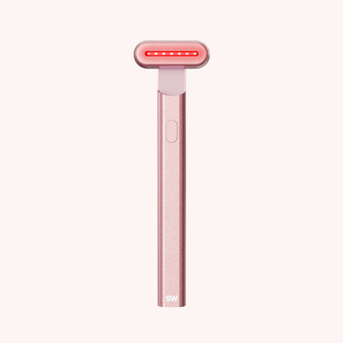 Rose-gold Solawave Radiant Renewal skincare wand with its red light head illuminated
