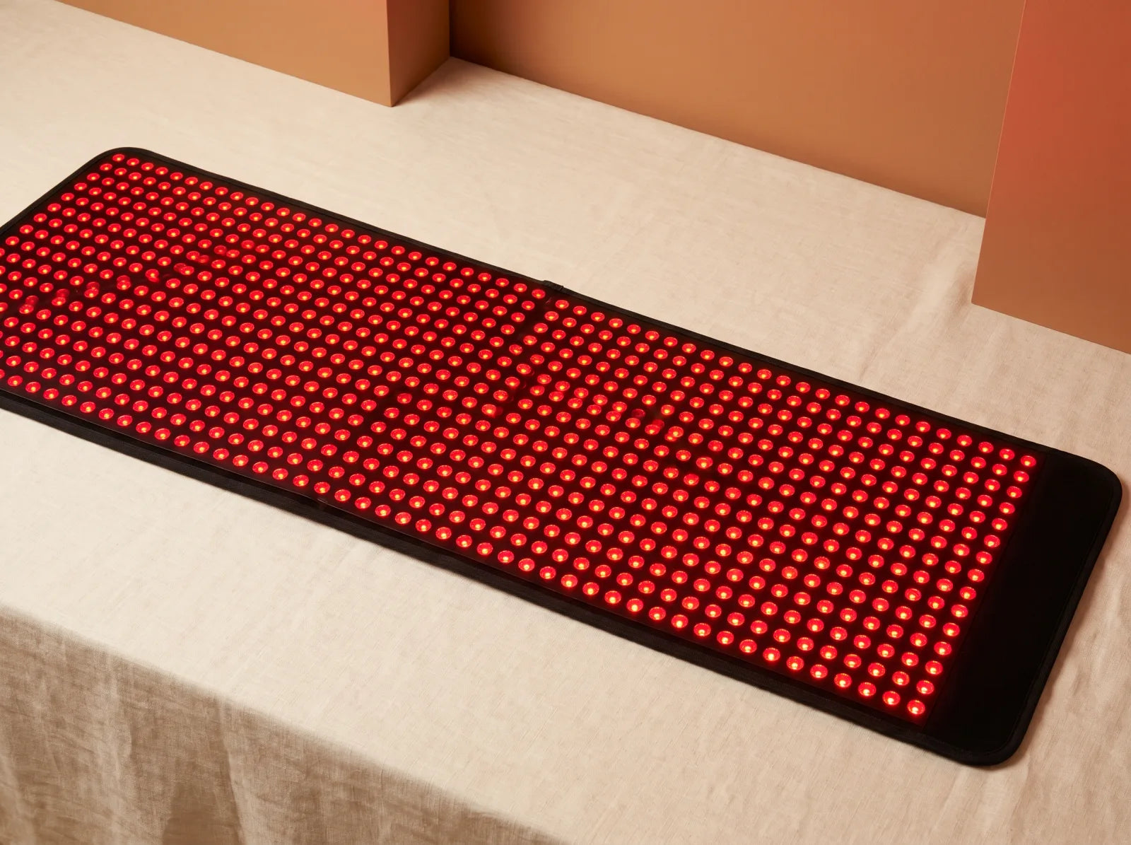 Red and near-infrared light therapy mat illuminated on a clean studio set